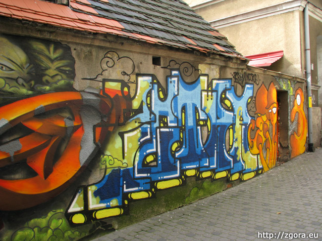 Graffiti zdobiące ścianę w wąskiej uliczce przy ul. ks. Piotra Wawrzyniaka